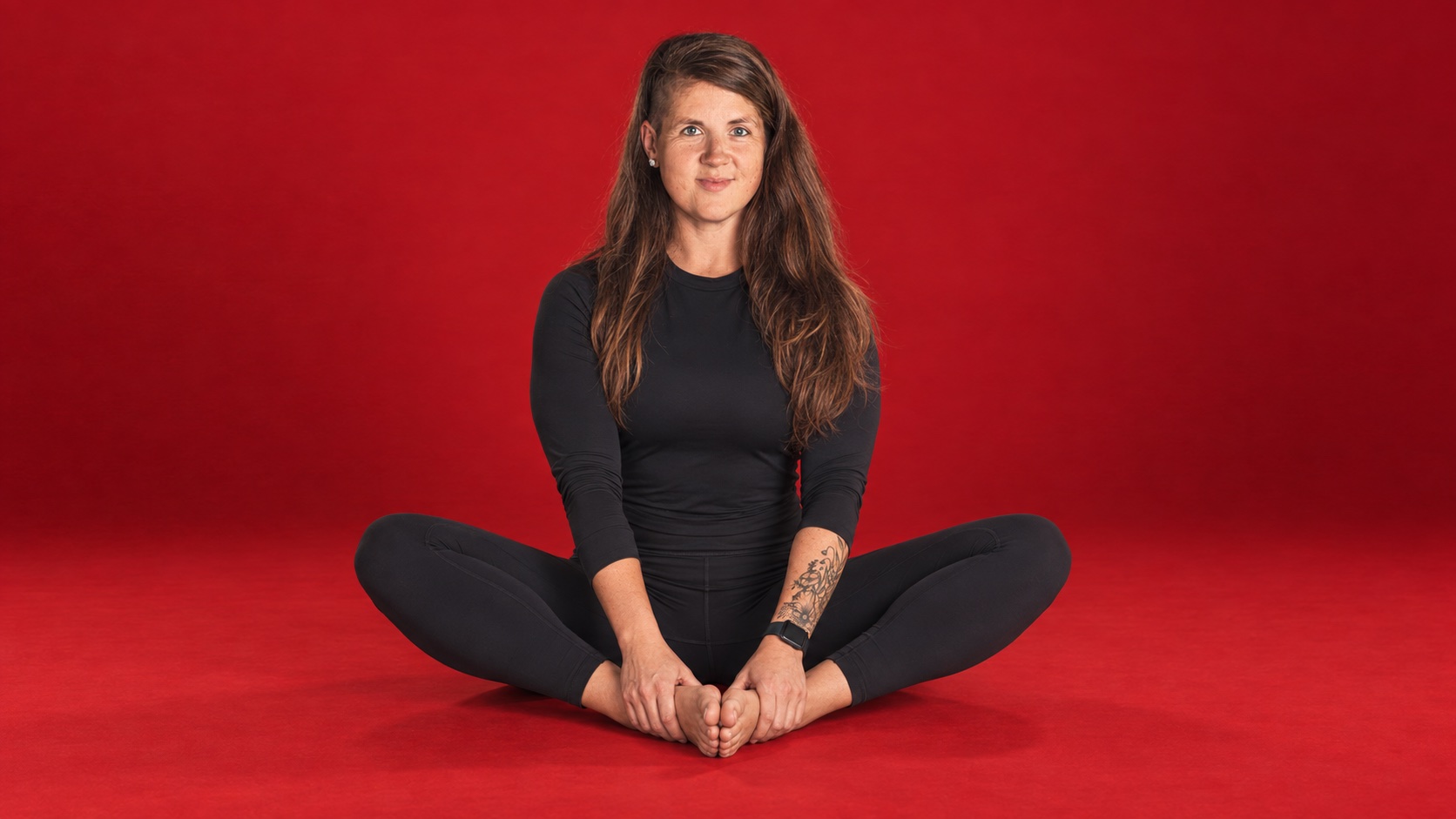 Kim Carson seated in butterfly stretch pose